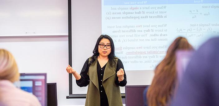 Professor Hannarae Lee teaching a class on Analyzing 刑事司法 Data speaking in front of a projector screen with notes about a T-test